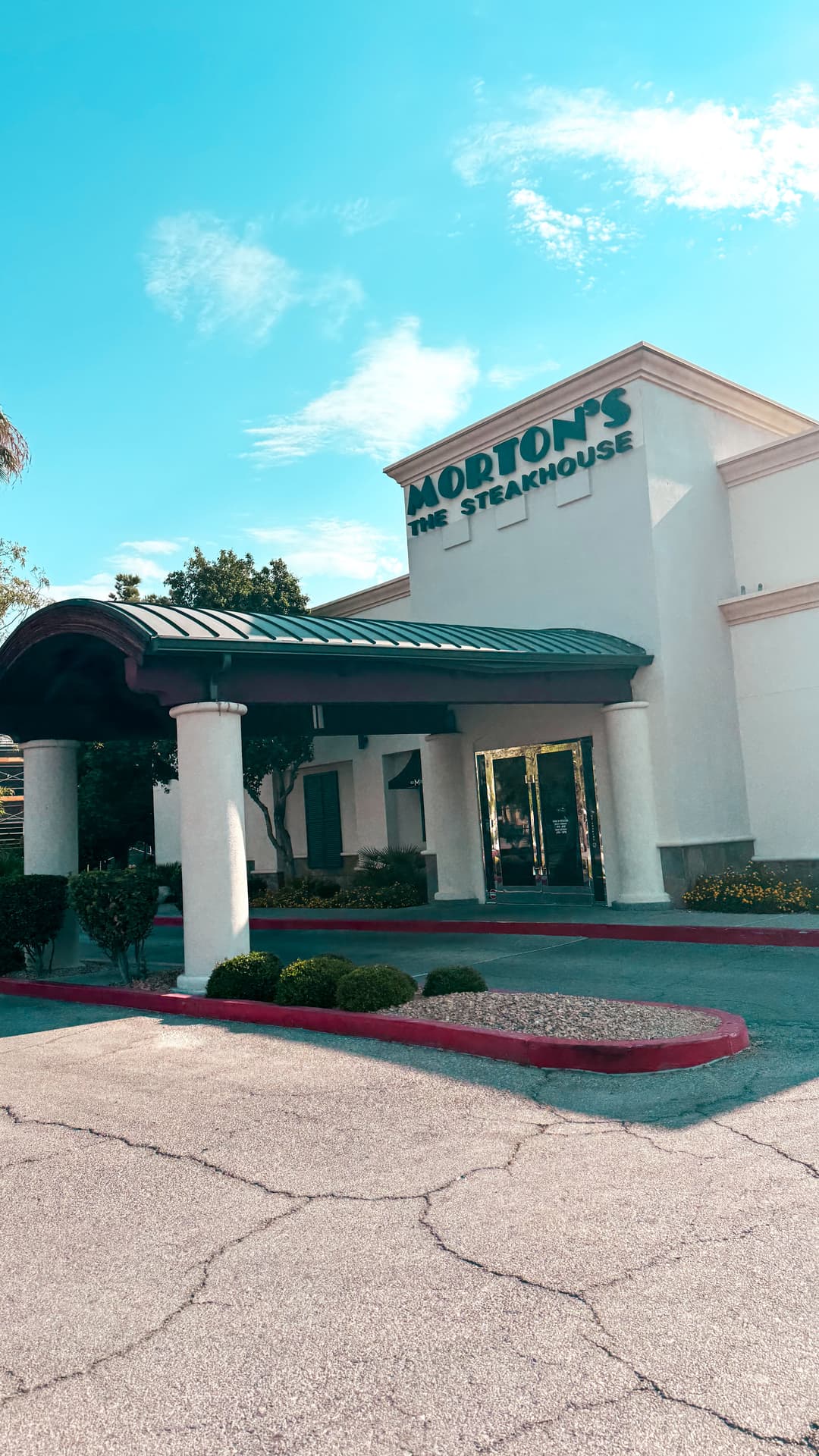 Morton's The Steakhouse exterior view with entrance and clear blue sky.